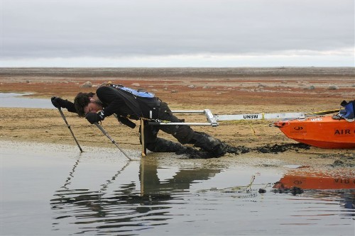 Chris leaning right over slowly hauling PAC through mud.