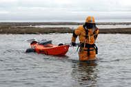 Clark wading across a river hauling PAC