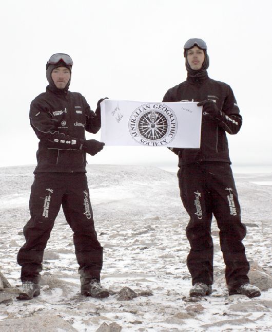 Chris and Clark holding the Australian Geographic Society banner at the end point of their 2005 expedition to Victoria Island